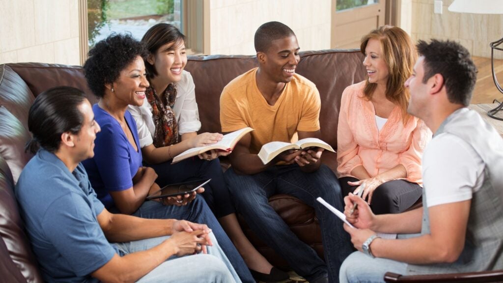 a group of men and women having a bible study small group
