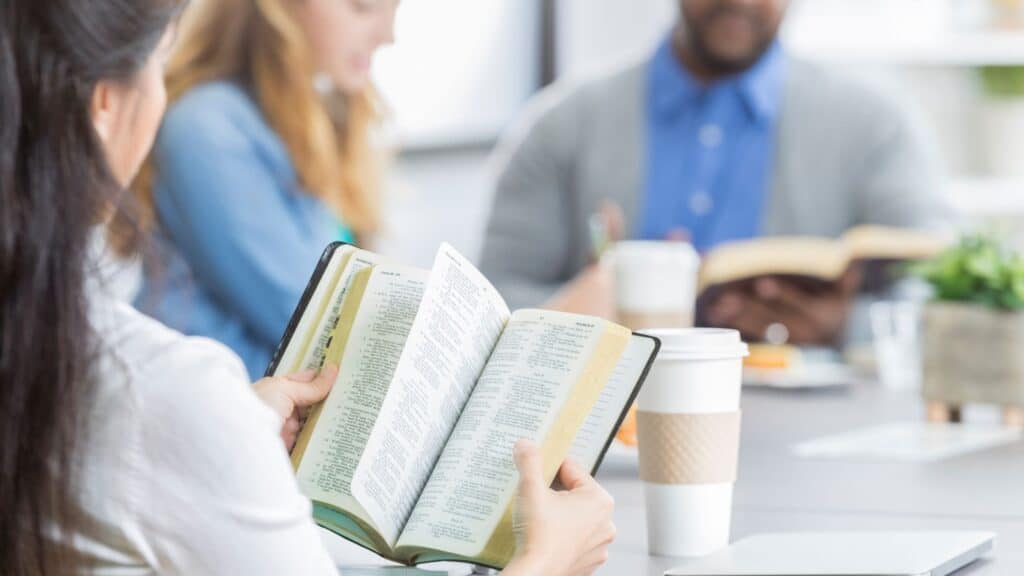 people sitting at a table doing group Bible study together